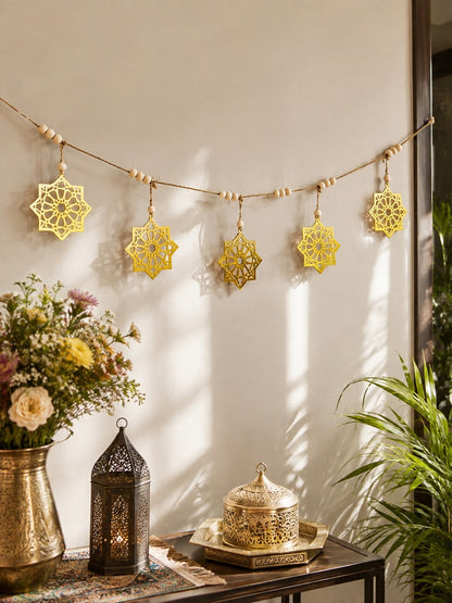 gold eight-point star garland styled in a room, photo 2