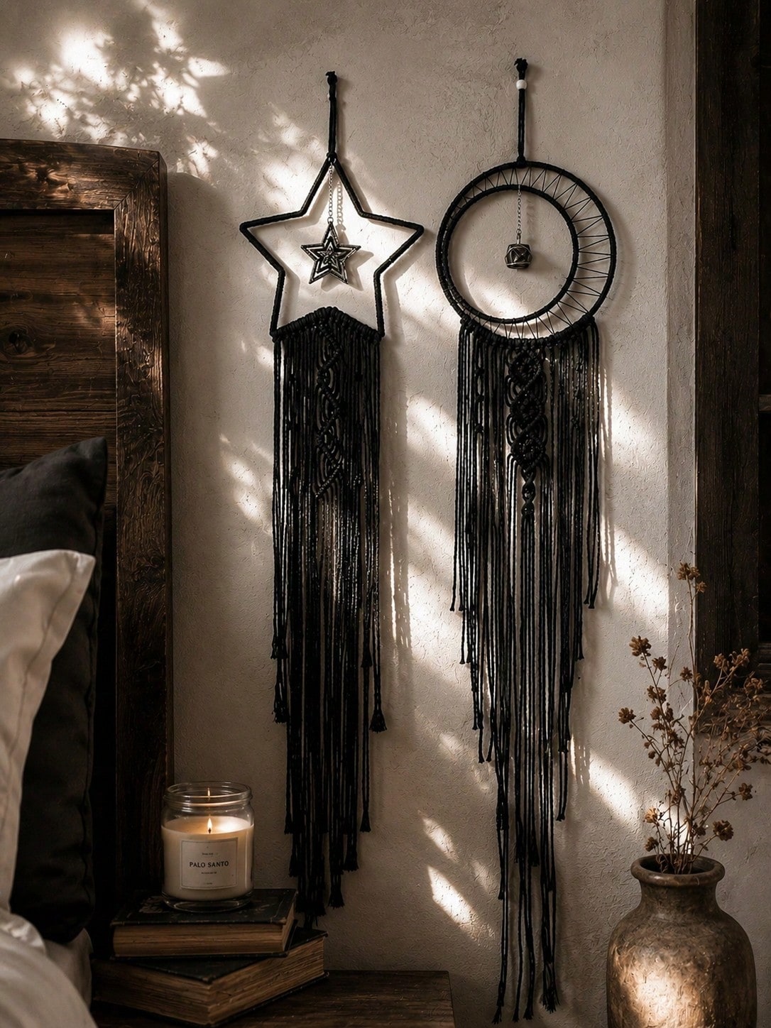 Black macrame moon dream catcher pair beside a bed with candle