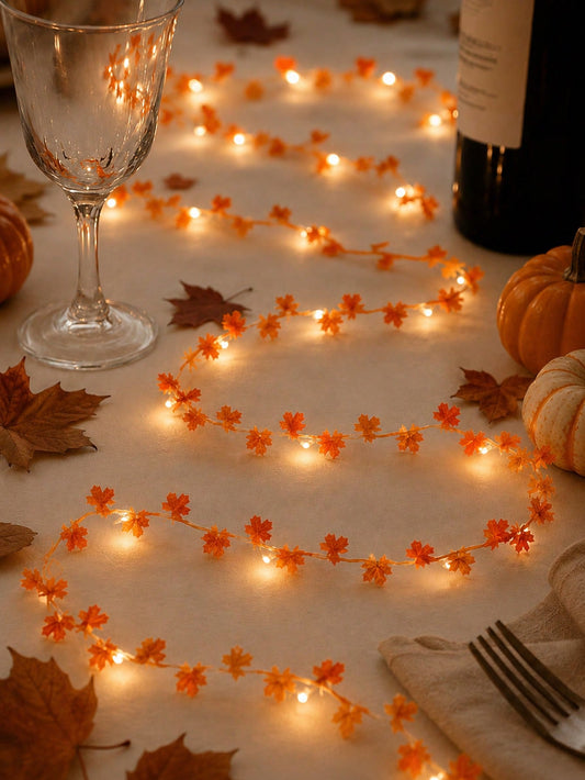 Maple leaf fairy string lights orange, on a table with wine glass