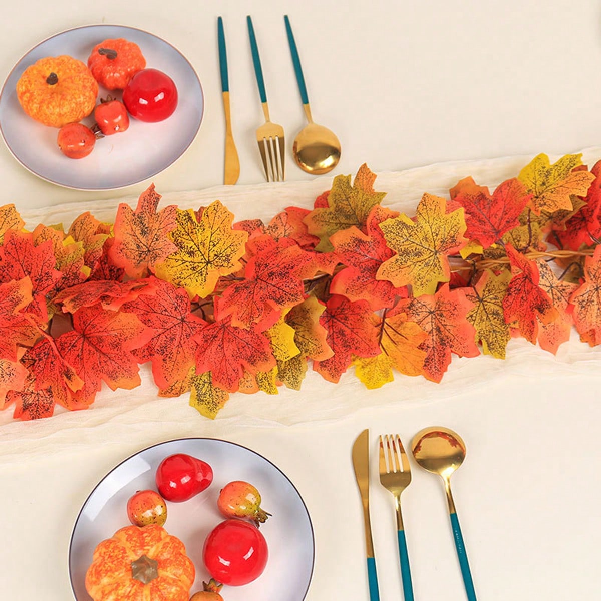 Artificial maple leaf garland in a table setting with pumpkins