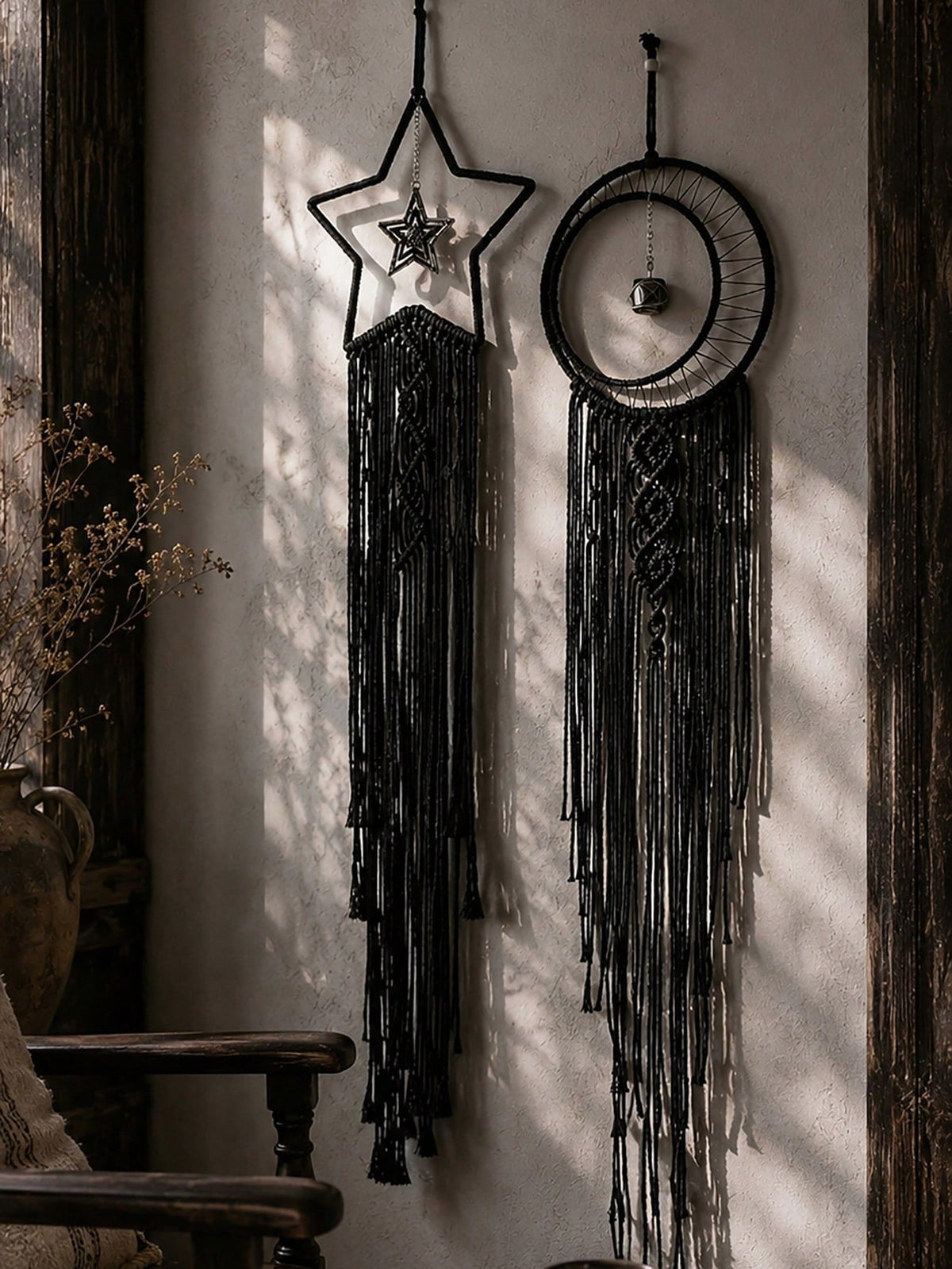 Black macrame moon dream catcher pair on a plaster wall