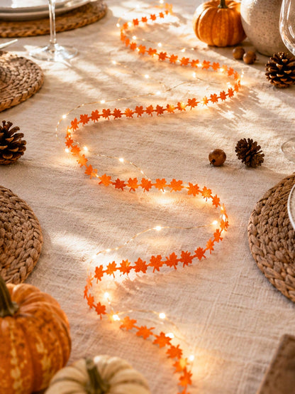 Maple leaf fairy string lights orange, on a table with pumpkins