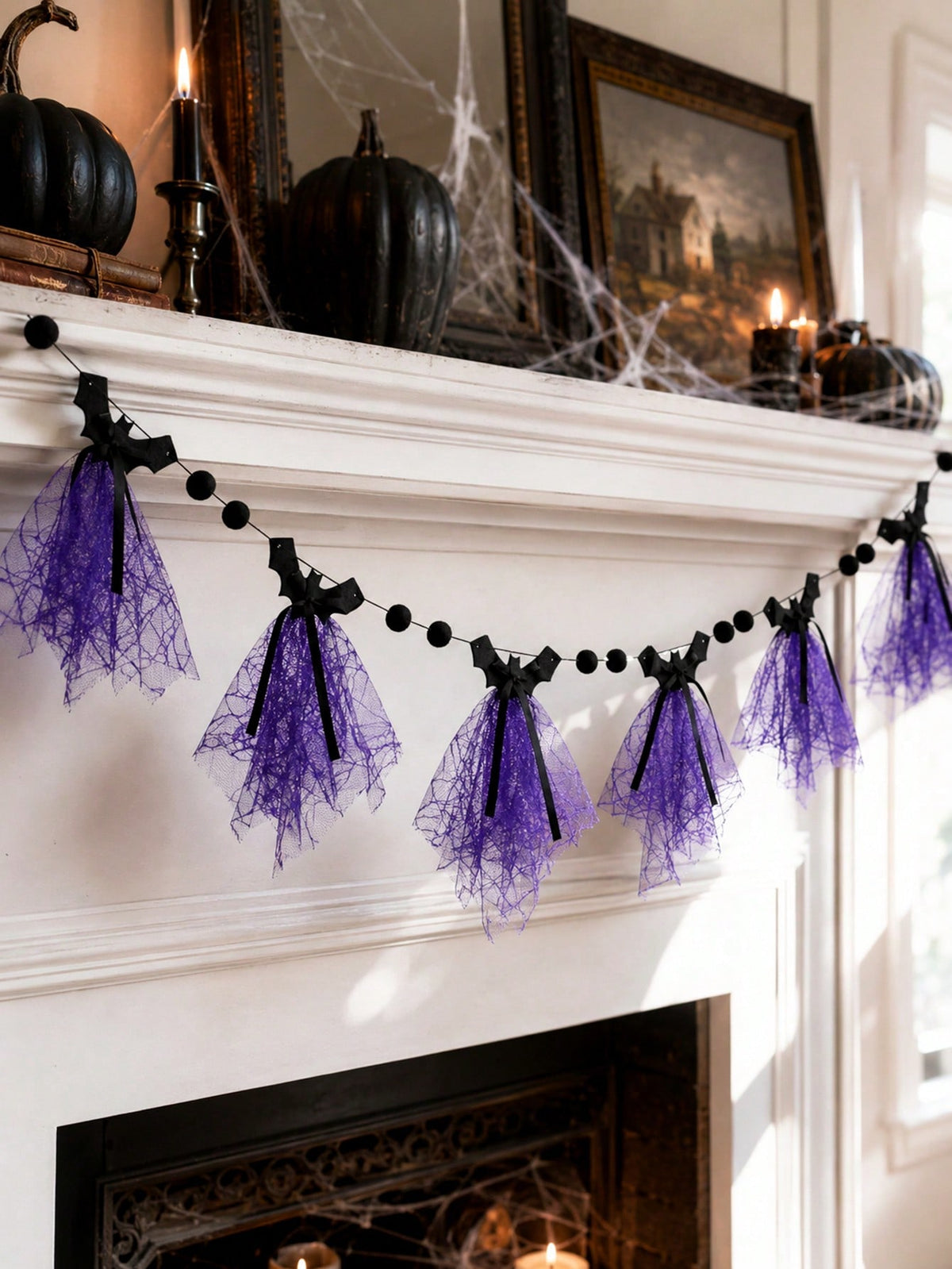 Purple bat Halloween banner on a mantel below framed art