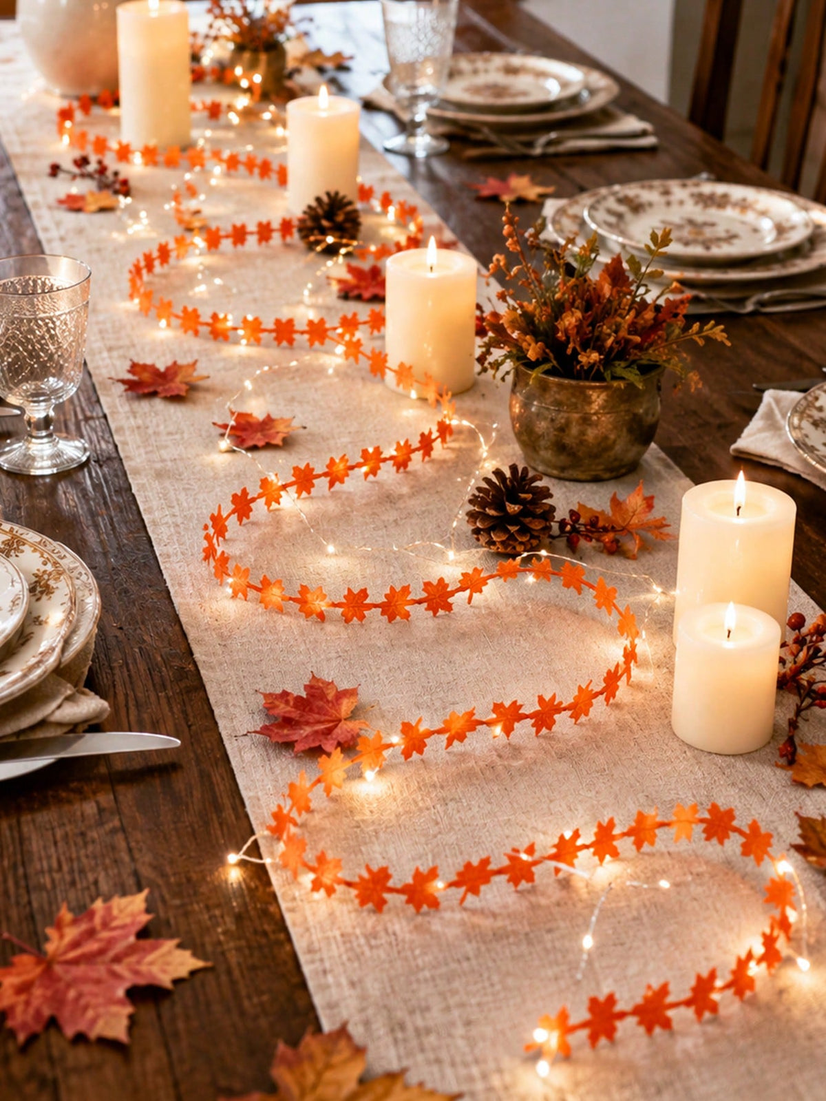 Maple leaf fairy string lights orange, along a table runner with candles