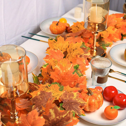 Artificial maple leaf garland on a table with candles