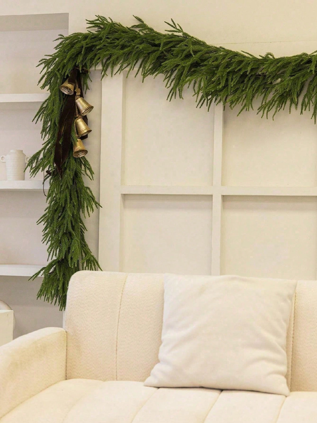 Artificial cedar Christmas swag framing a window above a sofa
