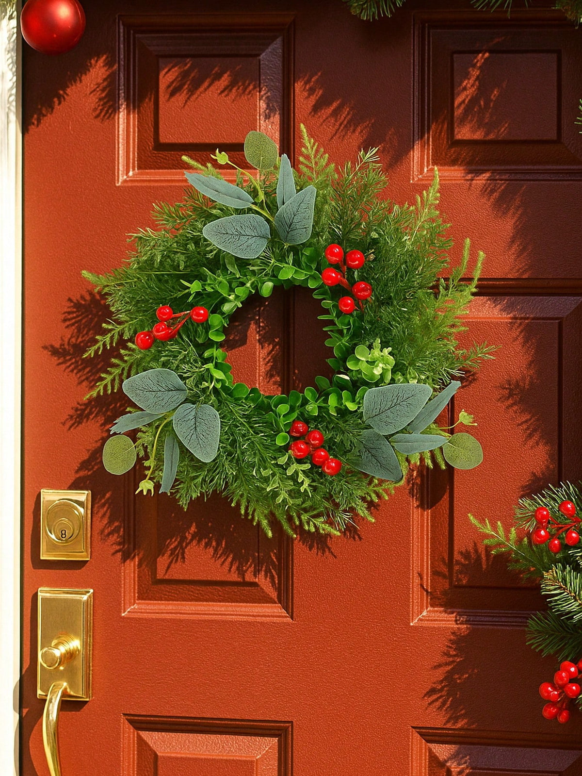 Eucalyptus and red berry Christmas wreath on a red front door
