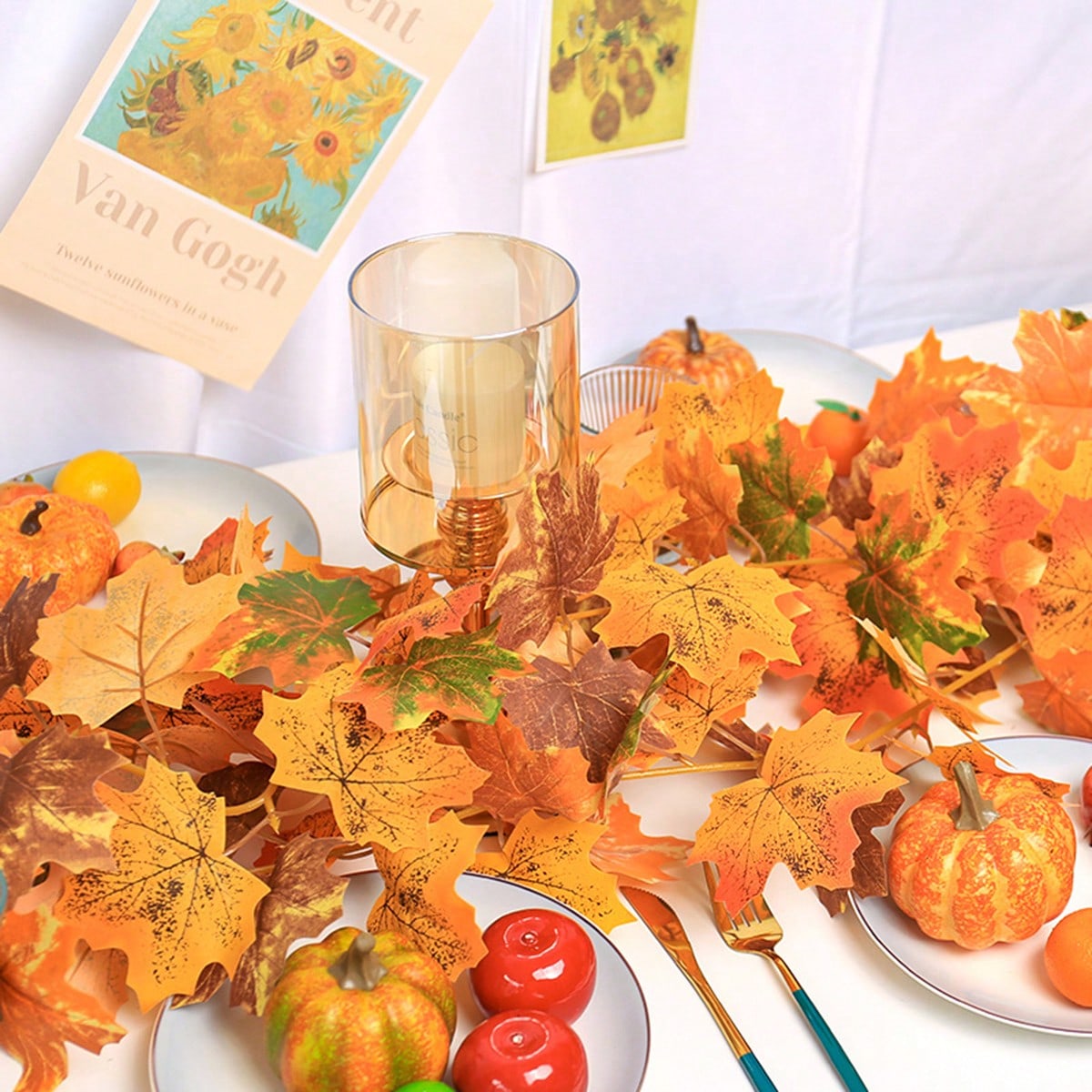 Artificial maple leaf garland on a table with a fall sign