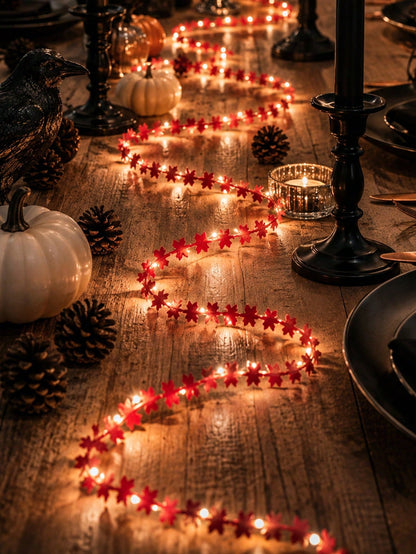 Maple leaf fairy string lights red, on a dark table