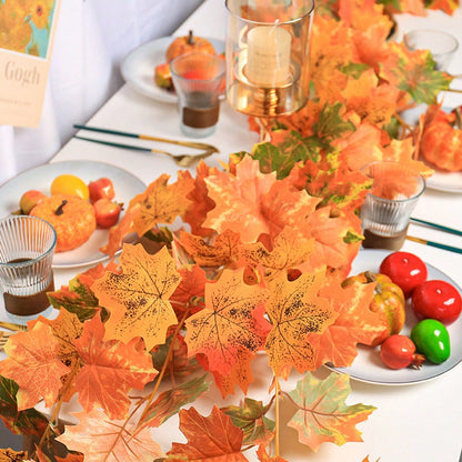 Artificial maple leaf garland on a table with fruit