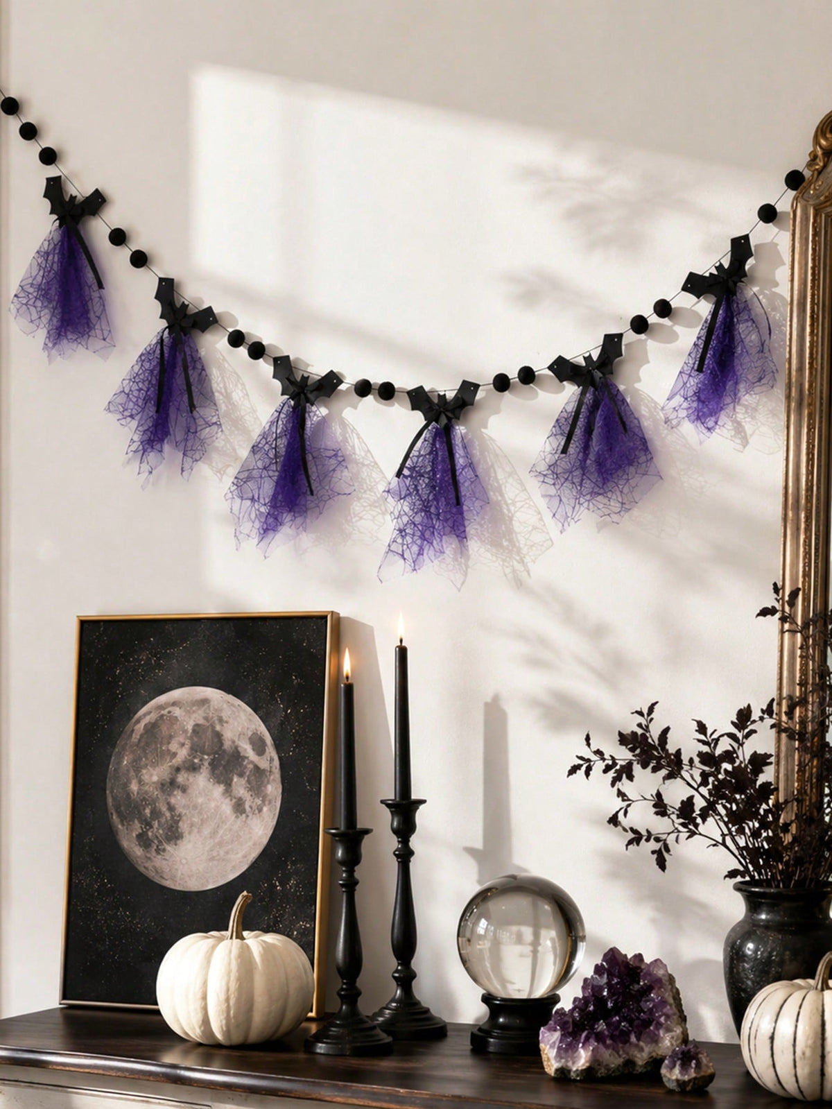 Purple bat Halloween banner on a wall above a table with moon print
