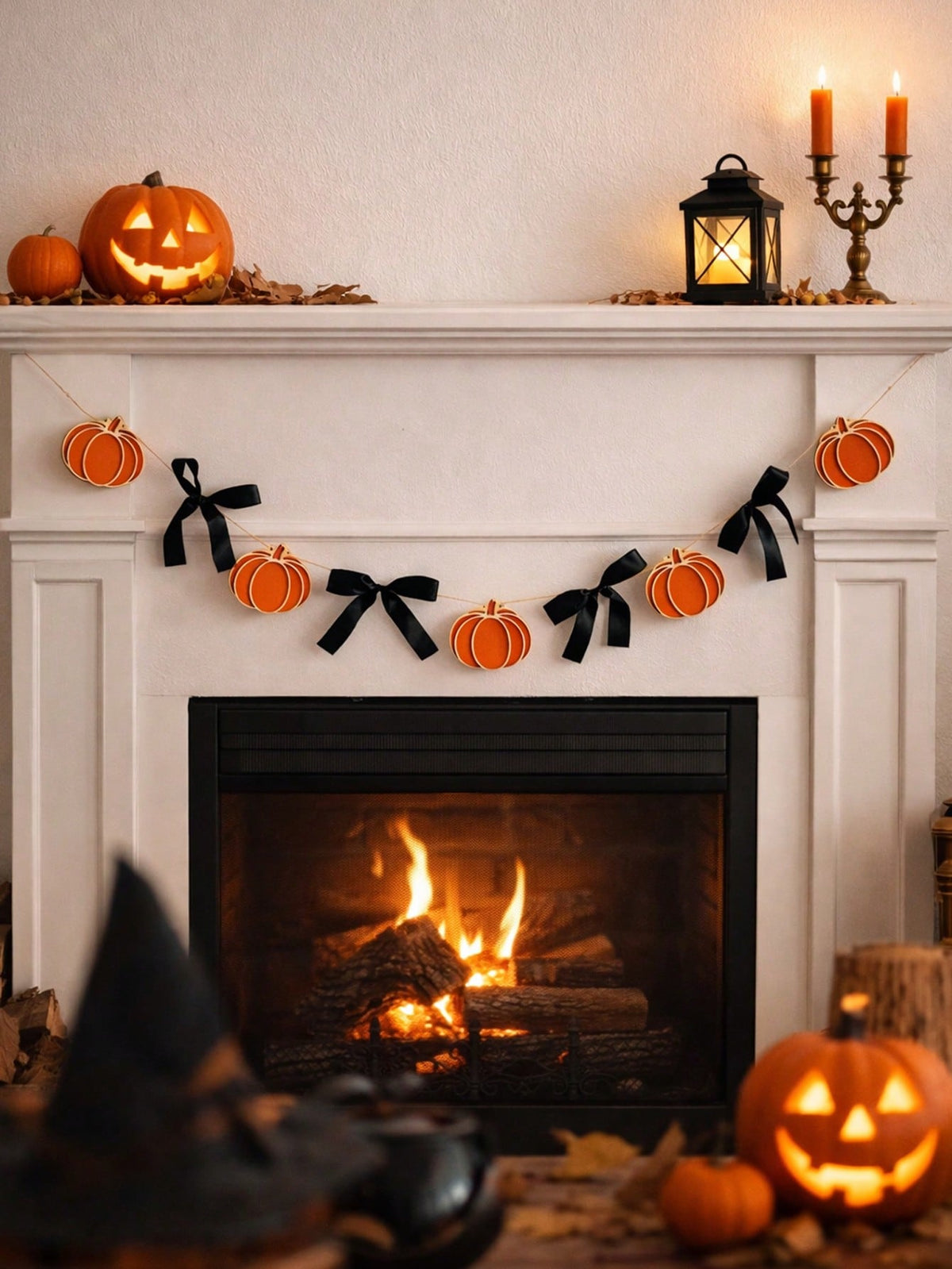Pumpkin garland with black bows over a lit fireplace