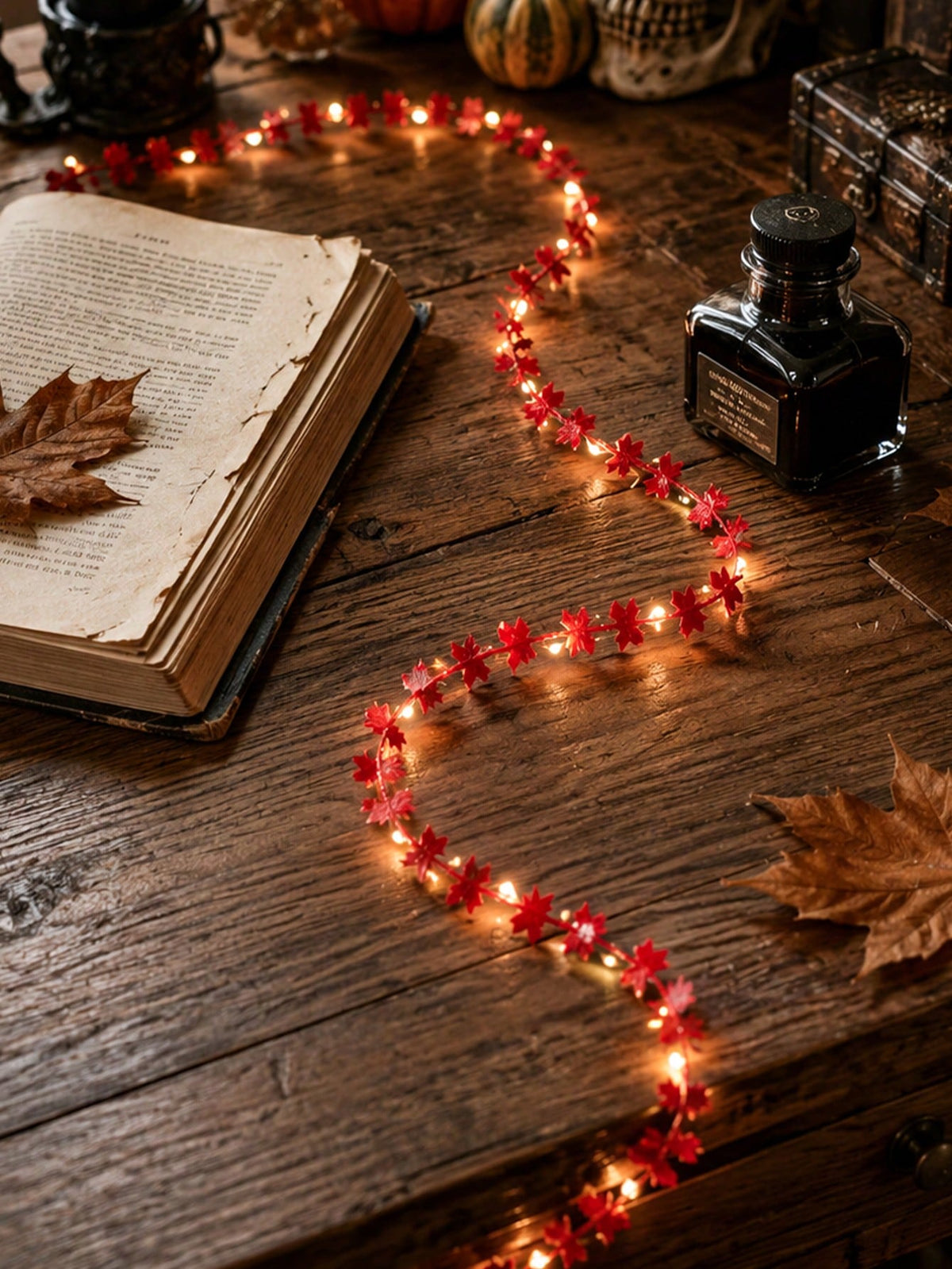 Maple leaf fairy string lights red, beside an old book