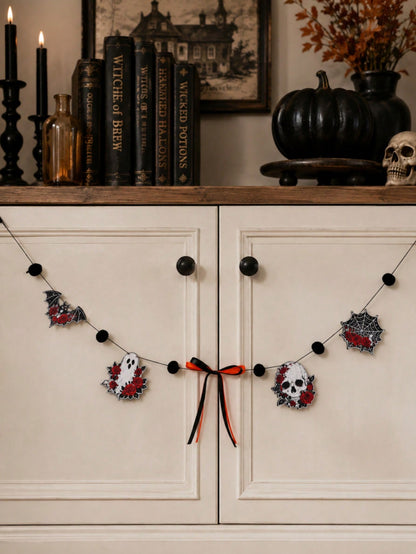 Gothic skull Halloween garland with roses across a white cabinet