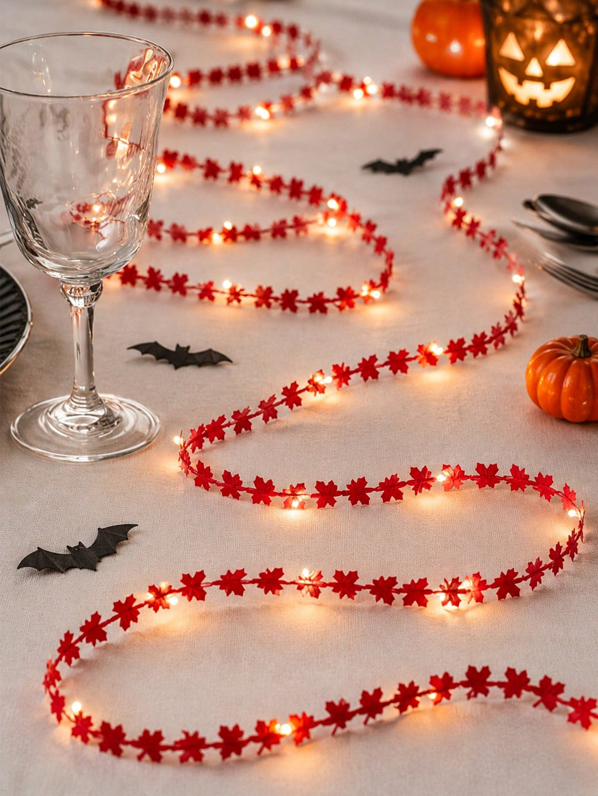 Maple leaf fairy string lights red, with a wine glass