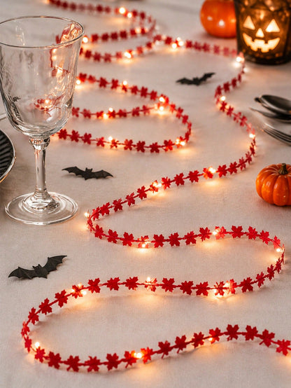 Maple leaf fairy string lights red, with a wine glass