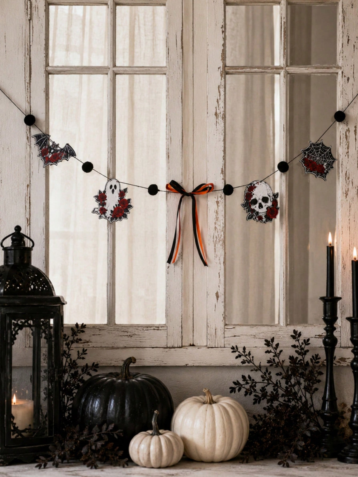 Gothic skull Halloween garland with roses in a window with lanterns